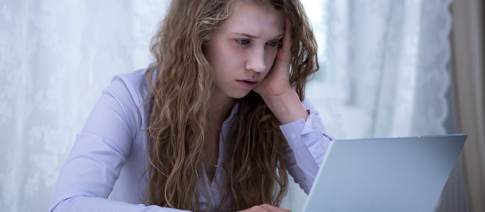 Ein junges Mädchen sitzt vor einen Laptop