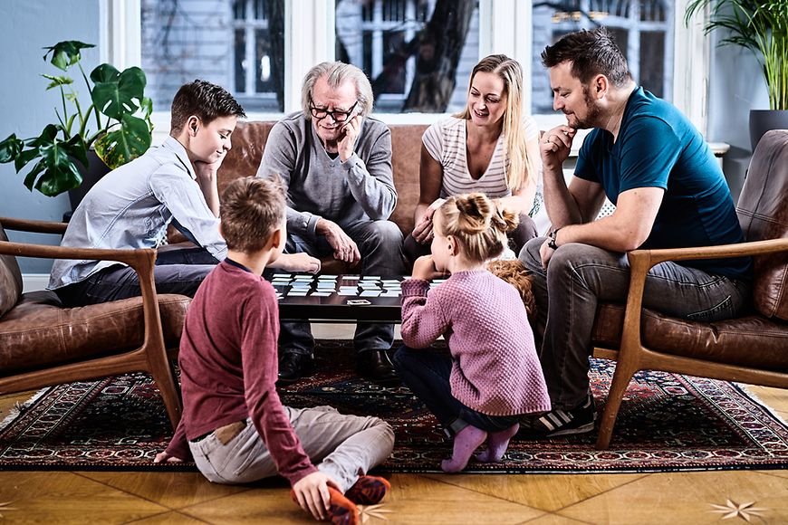 Eine Familie sitzt am Tisch und spielt