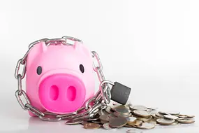 Ein Rosa Sparschwein, worum eine Kette mit Vorhängeschloss angelegt wurde