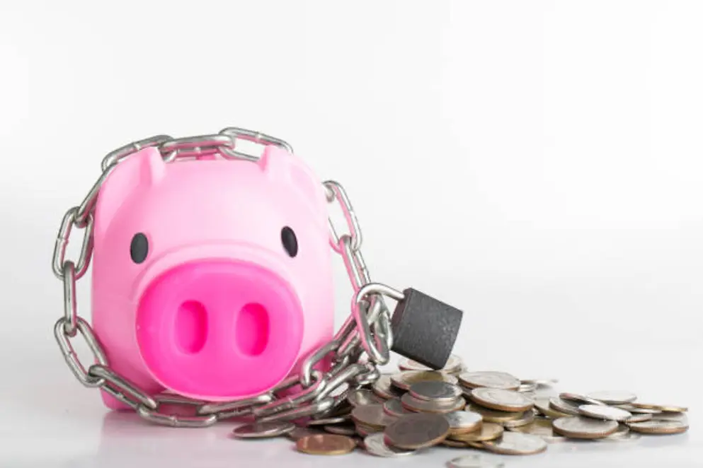 Ein Rosa Sparschwein, worum eine Kette mit Vorhängeschloss angelegt wurde